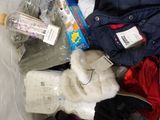 a bag full of clothes and a teddy bear on a bed