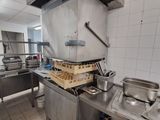 une cuisine équipée d'une cuisinière, d'un évier et d'autres appareils électroménagers