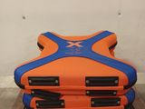 a stack of orange and blue luggage sitting on a wooden table
