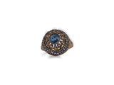 a close up of a ring with a blue stone in it