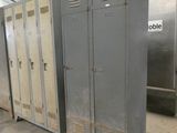 several metal lockers are lined up in a warehouse area