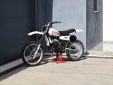 une moto tout-terrain garée devant un garage