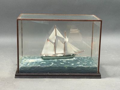 a glass case with a model of a sailboat in it