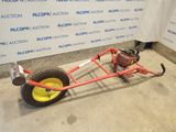a red cart with a yellow wheel on the floor