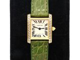 a close up of a wrist watch with a green band and roman numerals