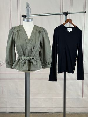 two women ' s tops on a mannequin stand in front of a white wall