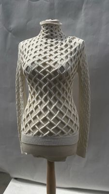 a white knitted sweater on a mannequin on a wooden stand