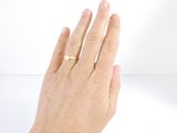 a woman ' s hand with a gold ring on it
