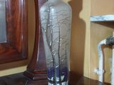 a glass vase sitting on top of a table next to a mirror