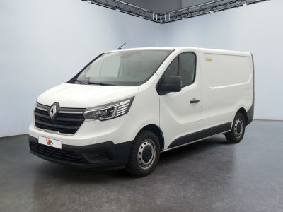 La camionnette blanche est garée dans une grande pièce.
