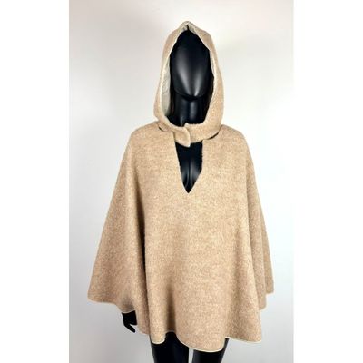 une femme portant une cape beige à capuche sur la tête