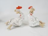 two figurines of chickens sitting next to each other