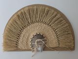 a fan that is hanging on the wall next to a piece of paper