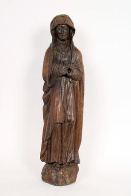une vieille statue en bois représentant une femme coiffée d'un chapeau