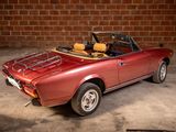 an image of a red convertible car parked in front of a brick wall