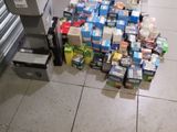une personne debout sur le sol, devant une pile de canettes de soda
