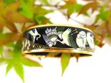 a black and gold ring with birds on it