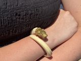someone is wearing a black dress and a gold ring on their arm