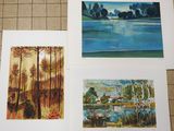 three paintings of trees and a lake are displayed on a tile floor