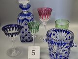 many different colored glass vases and glasses on the table