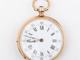 a gold pocket watch with roman numerals on the face