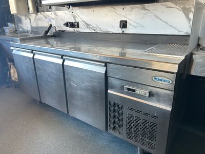 un grand plan de travail en inox sur lequel est posé un micro-ondes