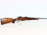 a rifle on a white surface with a white background