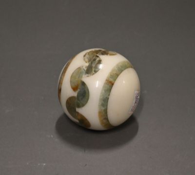 a close up of a white ball with green leaves on it