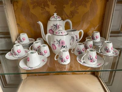 a glass shelf with a tea set and cups on it