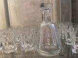 many glasses and a decanter sitting on a table