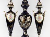 trois vases noirs et dorés ornés de motifs floraux sur fond blanc