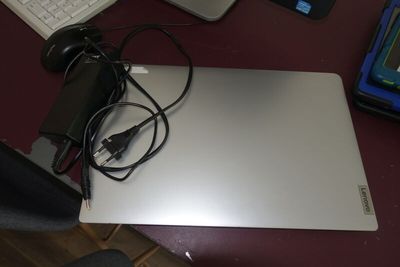 un ordinateur portable posé sur un bureau, à côté d'un clavier et d'une souris