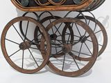 a small wooden carriage with wheels on a white surface
