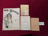 Trois livres sont posés sur une table recouverte d'un tissu rouge.