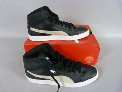 a pair of black and white sneakers sitting on top of a red box