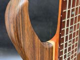 the neck of a bass guitar with a wooden body and neck rest
