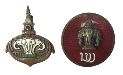 deux insignes métalliques représentant un éléphant et un bâtiment