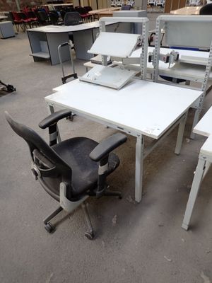 a white desk with two chairs and a computer on it
