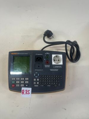 une calculatrice posée sur une table, à laquelle est relié un cordon