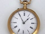 a gold pocket watch with roman numerals on the face