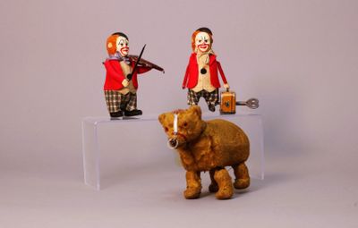 two figurines of clowns and a bear on a table