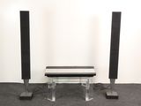 two speakers and a table in a room with a white wall