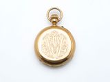 an image of a gold pocket watch with a monogram on the front