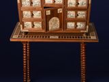 une petite table en bois avec des tiroirs et une horloge posée dessus