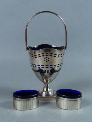 une image représentant une tasse argentée et deux tasses bleues posées sur une table