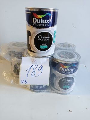 two cans of duluxx paint and a cup of coffee on a table
