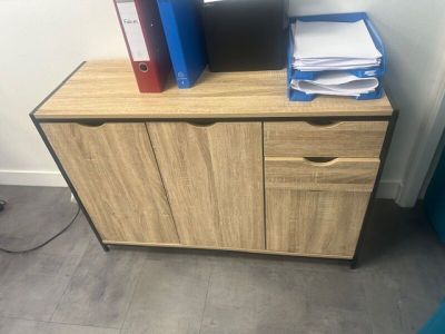 a desk with a computer, file cabinet and a monitor on it