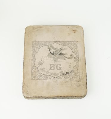 un vieux livre posé sur une table blanche à côté d'un mur blanc