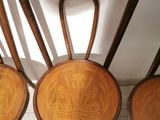 three wooden chairs sitting next to each other on top of a wooden floor