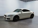 une Audi TT blanche aux jantes noires, garée dans une pièce blanche